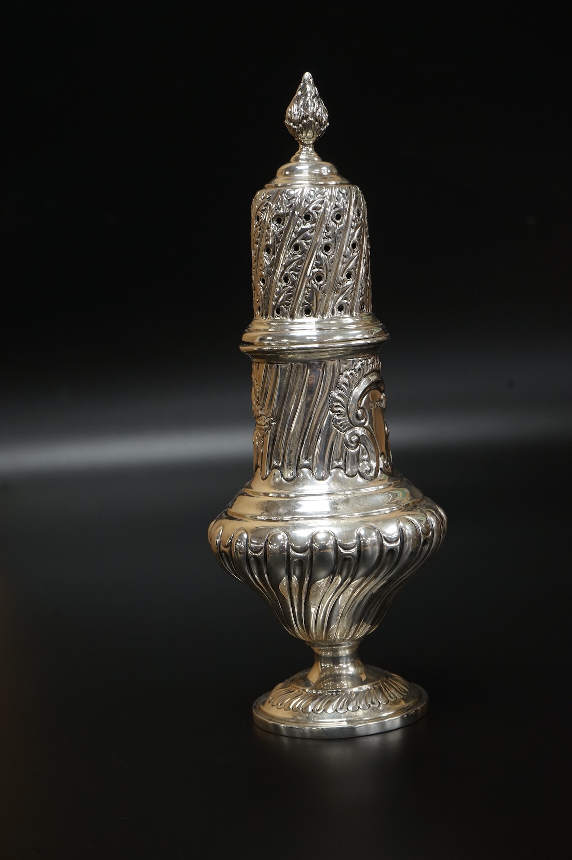 A Victorian embossed silver christening mug, on three ball feet, Martin, Hall & Co, London, 1874, height 85mm, together with a similar sugar caster, Lee & Wigful, Sheffield, 1899.
